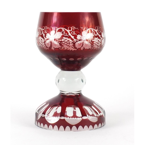 661 - Bohemian ruby glass table goblet, the bowl etched with vines and grapes on a faceted base, 22cm high