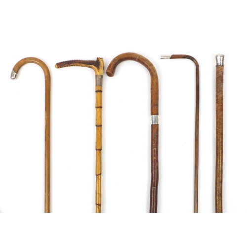 89 - Four walking sticks with silver mounts and a Swain and Co silver mounted riding crop, the largest 98... 