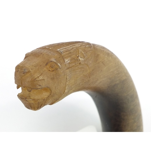 73 - Rhinoceros horn handled walking stick with segmented ivory shaft, the handle carved in the form of a... 
