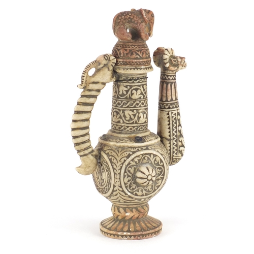 528 - Islamic stone wine ewer, carved with rams, elephant and foliate motifs, 36cm high