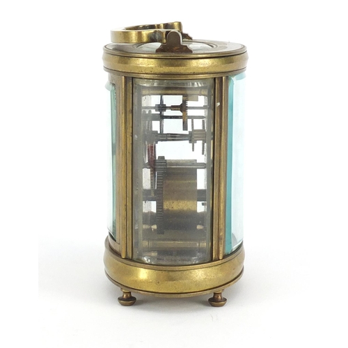 2332 - Oval brass cased carriage clock with enamelled dial and Roman numerals, 12cm high