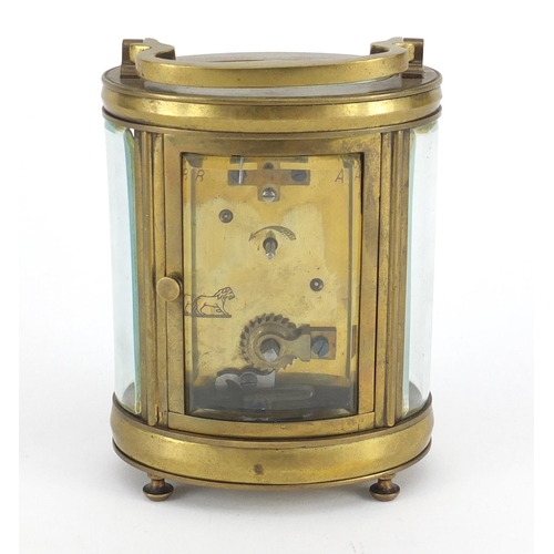 2332 - Oval brass cased carriage clock with enamelled dial and Roman numerals, 12cm high