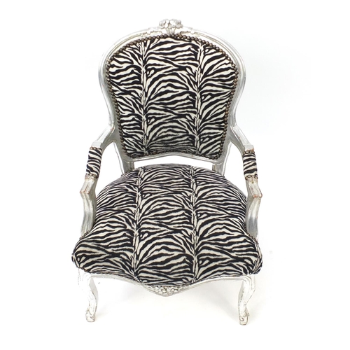33 - Ornate silvered open armchair with zebra pattern upholstery, 92cm high