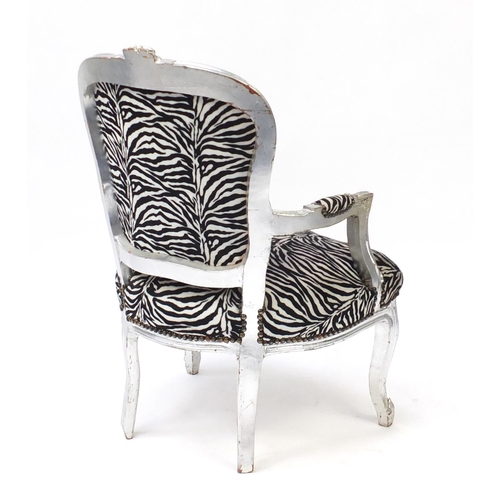 33 - Ornate silvered open armchair with zebra pattern upholstery, 92cm high