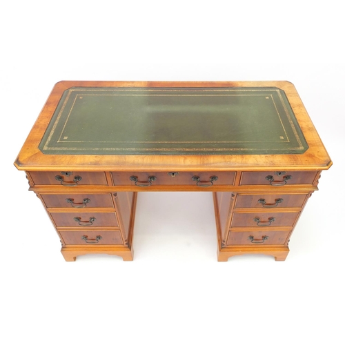 2 - Yew twin pedestal desk, with tooled green leather insert above nine drawers, 78cm H x 123cm W x 62cm... 