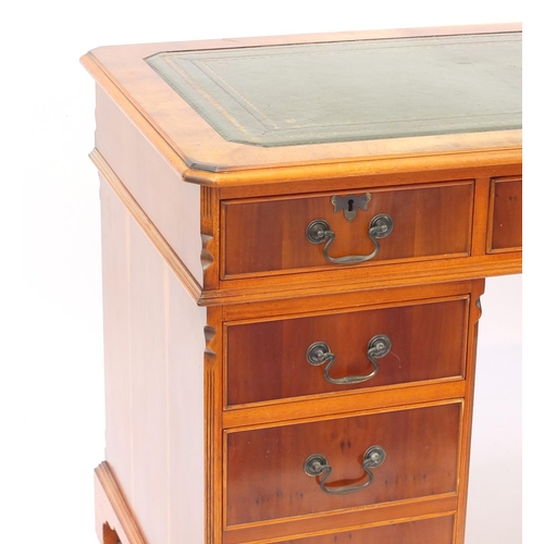 2 - Yew twin pedestal desk, with tooled green leather insert above nine drawers, 78cm H x 123cm W x 62cm... 