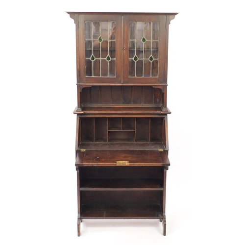 12 - Arts & Crafts oak bureau bookcase with a pair of leaded glass doors above a fall, frieze drawer and ... 