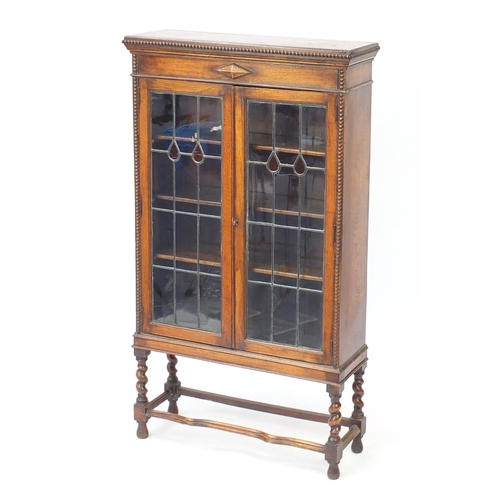 44 - Oak Arts & Crafts style bookcase, with leaded glass doors and three adjustable shelves, 141cm H x 80... 