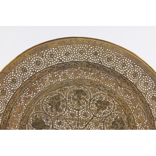 571 - Good Persian gilt copper dish, finely pierced and engraved with figures and flowers, 23cm in diamete... 