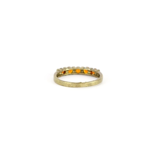 2880 - 9ct gold orange stone half eternity ring, size T, 2.4g