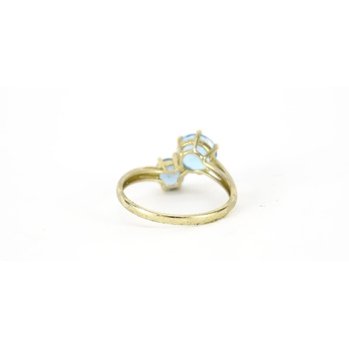 2748 - 9ct gold blue stone crossover ring, size T, 2.7g