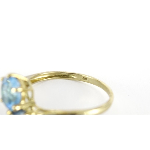 2748 - 9ct gold blue stone crossover ring, size T, 2.7g