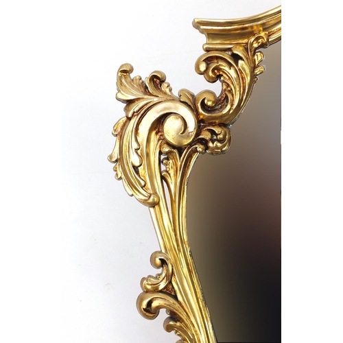 2056 - Ornate gilt framed cartouche shaped mirror, 74cm x 54cm