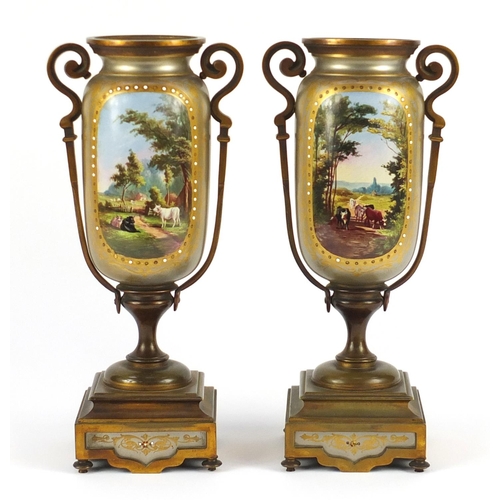 2242 - Pair of continental porcelain garniture vases, with bronzed metal mounts, each with panels of landsc... 