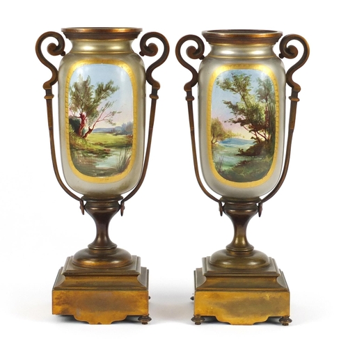 2242 - Pair of continental porcelain garniture vases, with bronzed metal mounts, each with panels of landsc... 