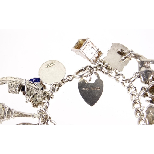 2913 - Silver charm bracelet with a selection of mostly silver charms including classic car, fish, lion and... 