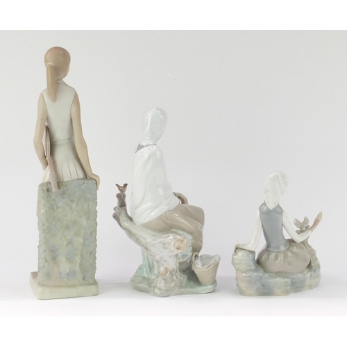 2313 - Three Lladro figurines comprising a tennis player and two girls seated with birds, the largest 32cm ... 