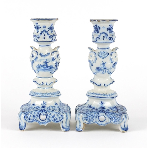 241 - Pair of Delft blue and white candlesticks with grotesque mask columns, 24cm high