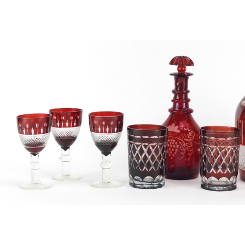 224 - Bohemian red flashed cut glassware including a decanter with six glasses, the largest 31cm high