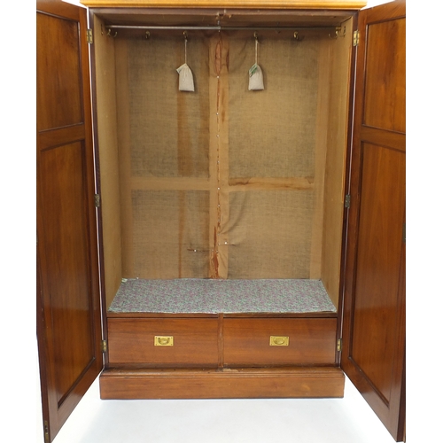 7 - Walnut two door wardrobe with fielded panel doors enclosing hanging space and two campaign style dra... 
