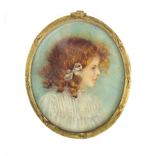 2339 - Oval portrait miniature of a young red headed girl, housed in a gilt metal pendant mount, the miniat... 