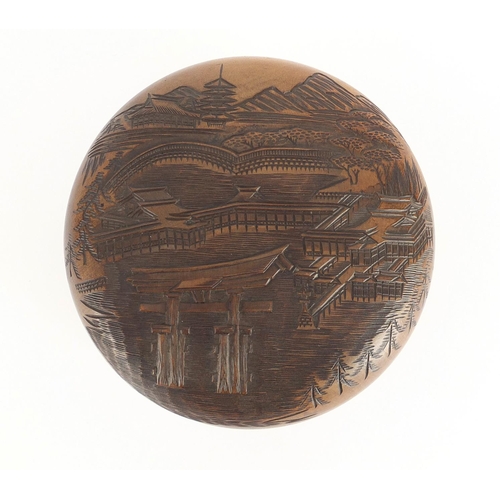 2233 - Chinese wooden bun box and cover, carved with a palace before a pagoda and mountains, 18.5cm in diam... 