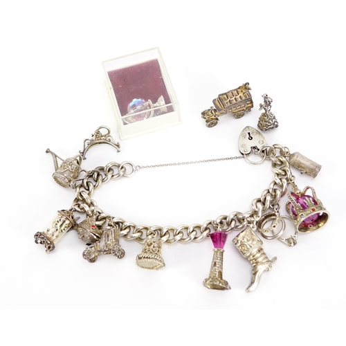 2432 - Silver charm bracelet with a selection of mostly silver charms including watering can, carriage cloc... 