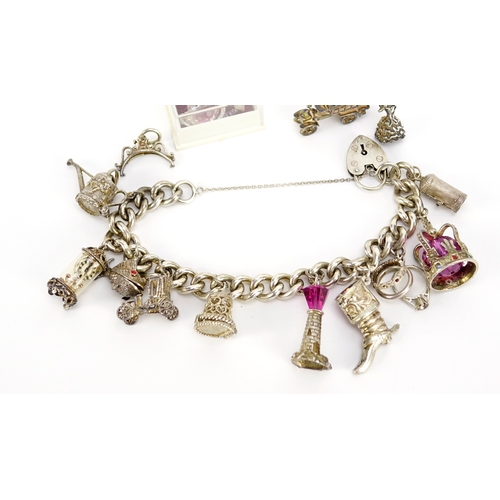 2432 - Silver charm bracelet with a selection of mostly silver charms including watering can, carriage cloc... 
