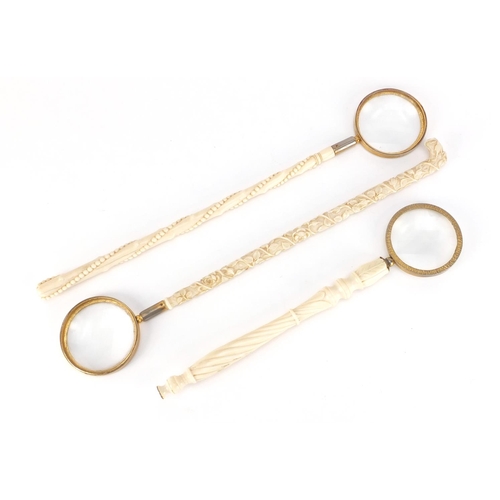 101 - Three Victorian carved ivory parasol handles converted to magnifying glasses, including one profusel... 