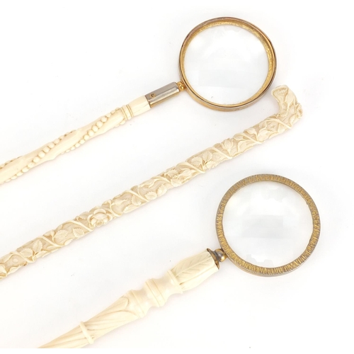 101 - Three Victorian carved ivory parasol handles converted to magnifying glasses, including one profusel... 