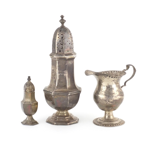 944 - Two octagonal silver baluster shaped casters and a pedestal milk jug, various hallmarks, the largest... 