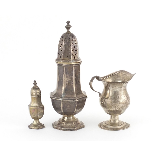 944 - Two octagonal silver baluster shaped casters and a pedestal milk jug, various hallmarks, the largest... 