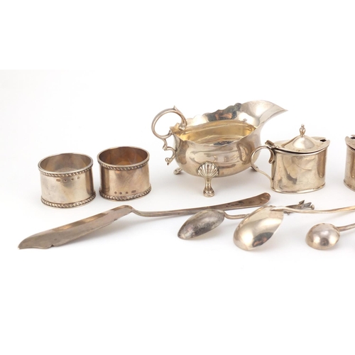 946 - Georgian and later silver objects including three footed sauce boat, three mustards with blue glass ... 