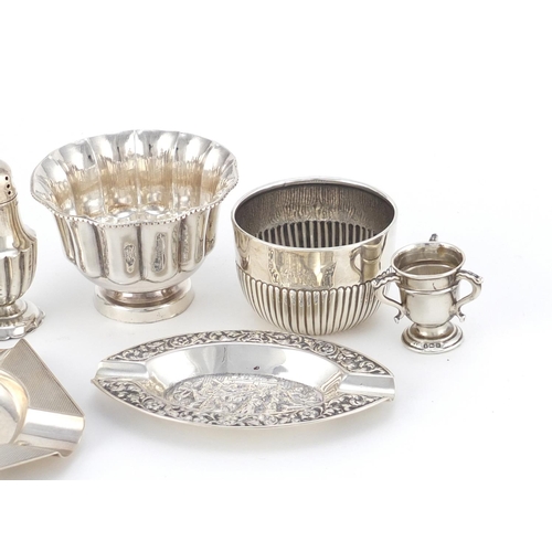 947 - Silver items including two circular bowls, a miniature tig trophy and two ashtrays, various hallmark... 