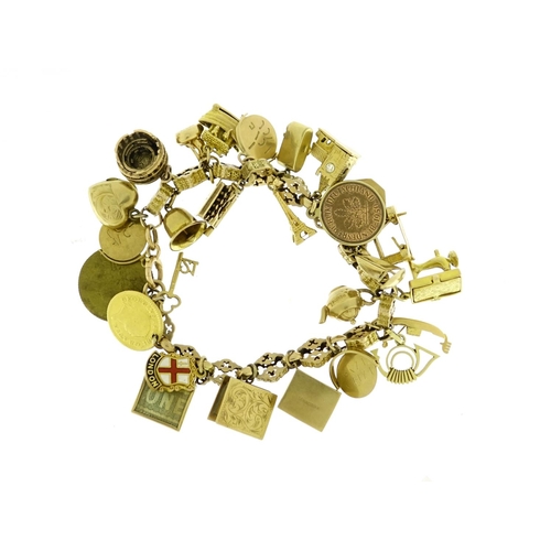 960 - 9ct gold charm bracelet with a large selection of mostly gold charms including London Bridge, Eiffel... 