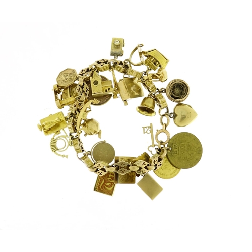 960 - 9ct gold charm bracelet with a large selection of mostly gold charms including London Bridge, Eiffel... 
