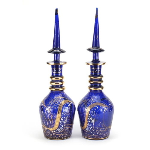 799 - Pair of blue glass decanters made for the Islamic market with gilded decoration, each 48.5cm high