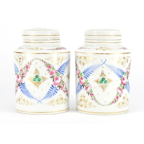 791 - Pair of continental porcelain canisters with covers, hand painted and gilded with flowers, 17cm high