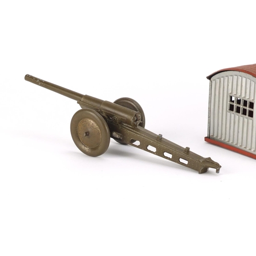 353 - German tin plate garage with clock work racing car and a Marx Toys field gun