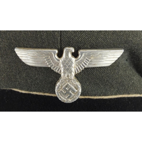 311 - German Military interest visor cap with badges and part label to the interior