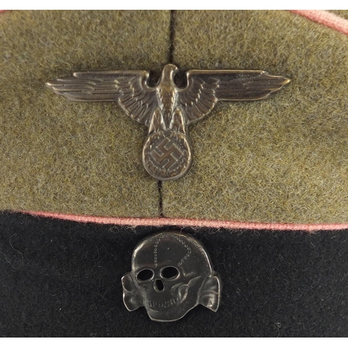 314 - German Military interest visor cap with badges