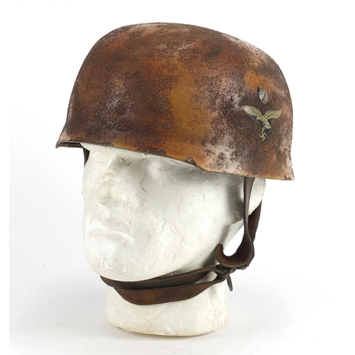 304 - German Military interest tin helmet with decals and leather liner, impressed marks to the interior