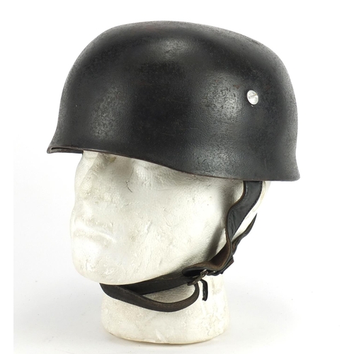 307 - German Military interest tin helmet with decal and leather liner, stamped marks and impressed number... 