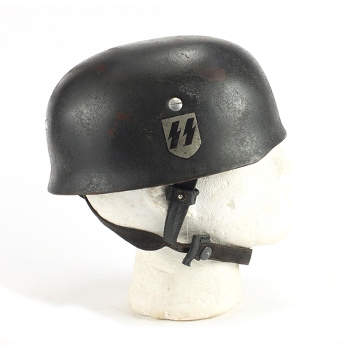 307 - German Military interest tin helmet with decal and leather liner, stamped marks and impressed number... 