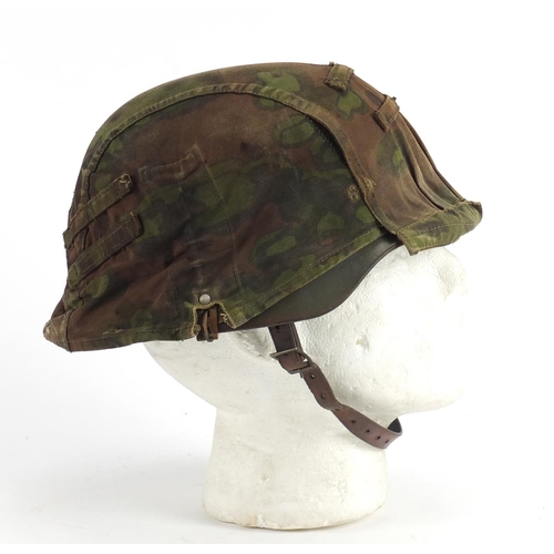 302 - German Military interest tin helmet with cover and leather liner, impressed marks to the interior