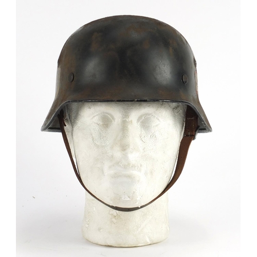 305 - German Military interest tin helmet with decals and leather liner, inscriptions and impressed marks ... 