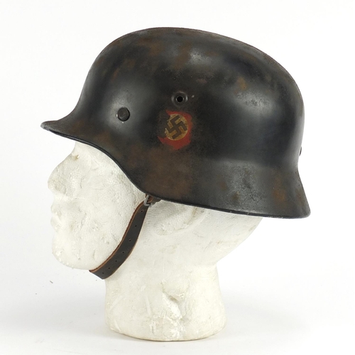 305 - German Military interest tin helmet with decals and leather liner, inscriptions and impressed marks ... 