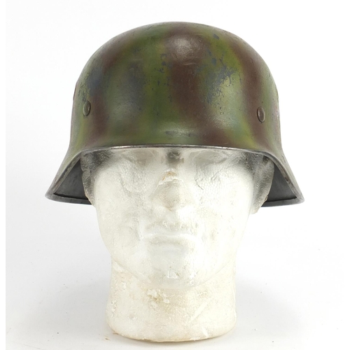 305A - German Military interest tin helmet with decals and leather liner, indistinct inscriptions to the in... 