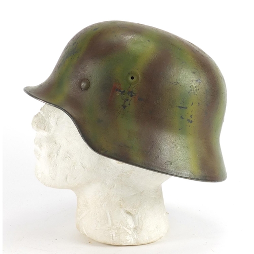305A - German Military interest tin helmet with decals and leather liner, indistinct inscriptions to the in... 