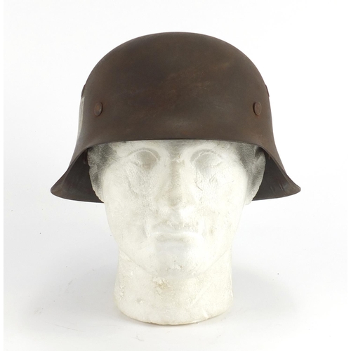 310 - German Military interest tin helmet with decals, impressed marks to the interior